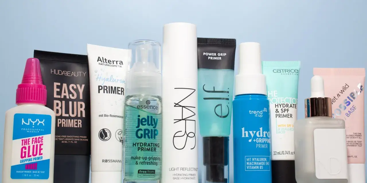 Eine Reihe von Make-up-Primern in verschiedenen Größen und Marken, auf hellblauem Hintergrund.