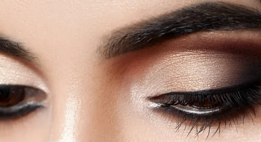 Nahaufnahme von Augen mit dezentem, strahlendem Make-up in Gold- und Brauntönen.