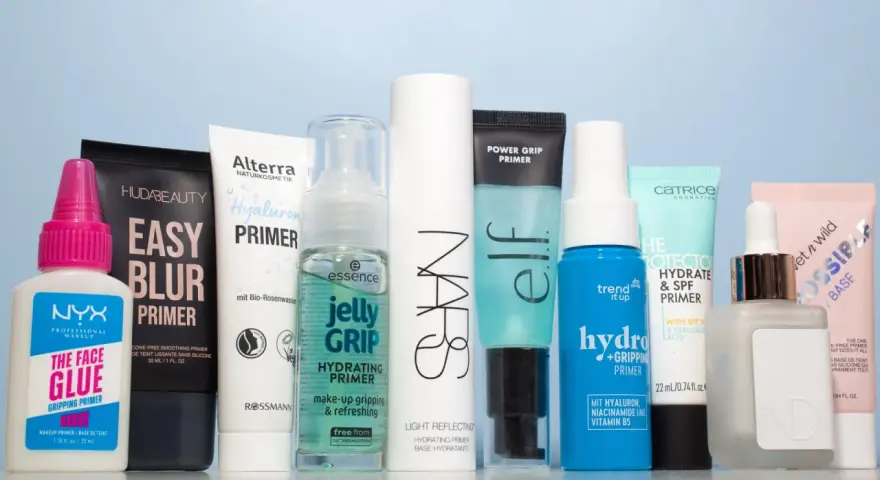 Eine Reihe von Make-up-Primern in verschiedenen Größen und Marken, auf hellblauem Hintergrund.